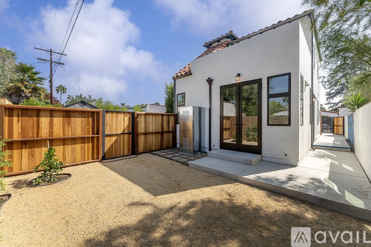 A modern house with a white exterior and a brown fence.