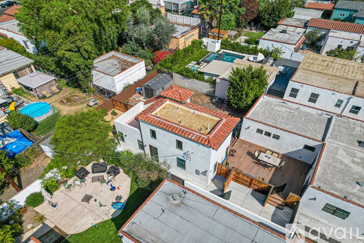 A bird's eye view of a residential area with a white house in the center.