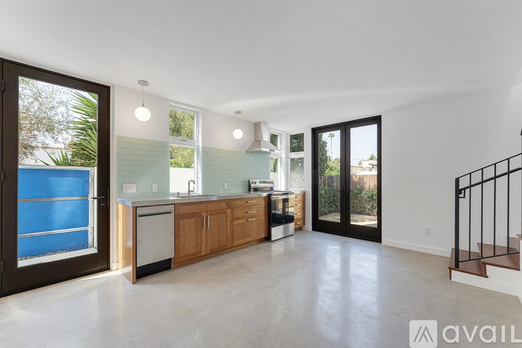 A spacious kitchen with wooden cabinets and a blue door.