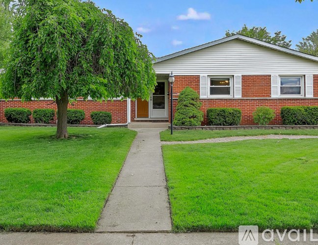 A house with a red brick wall and a white door is for sale.