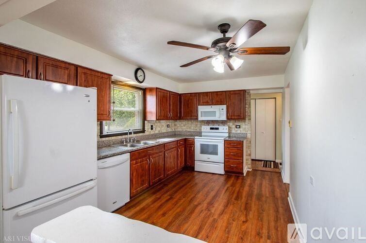 A kitchen with wooden cabinets and a white fridge.