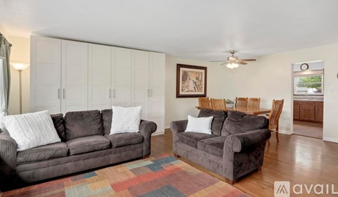 A living room with two couches and a rug.