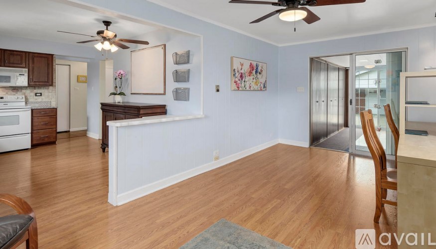 A living room with a wooden floor and a ceiling fan.