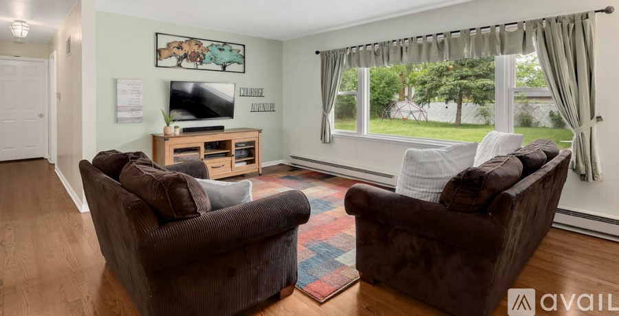 A living room with two brown chairs and a television.