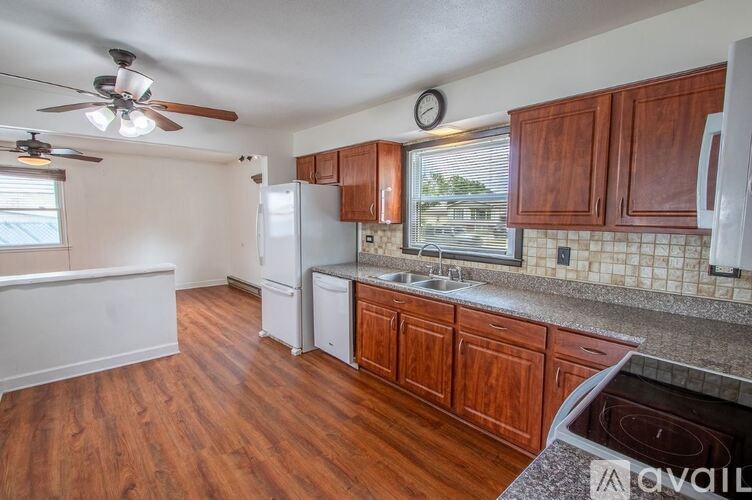 A kitchen with wooden cabinets and a white fridge.