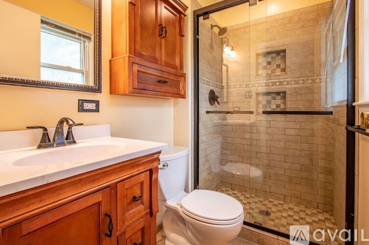 A bathroom with a toilet, sink, and shower.