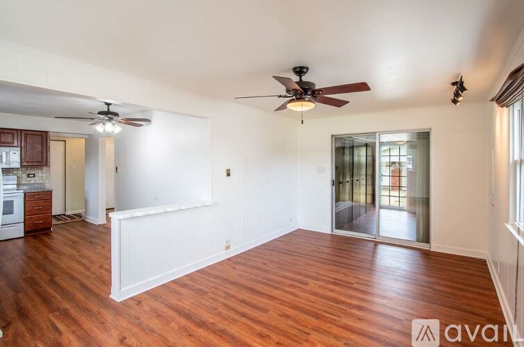 A room with wooden floors and a ceiling fan.