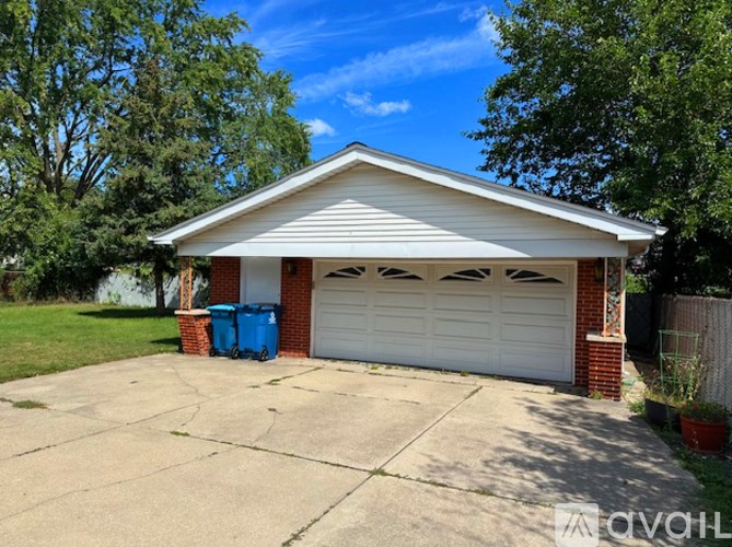 A two-car garage with a white roof and a brick pillar on the left side.