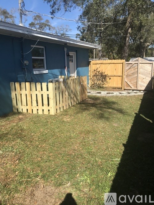 A blue house with a wooden fence in front.