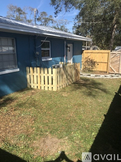 A blue house with a wooden fence in front.