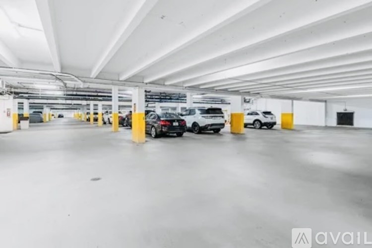 A parking garage with several cars parked in it.