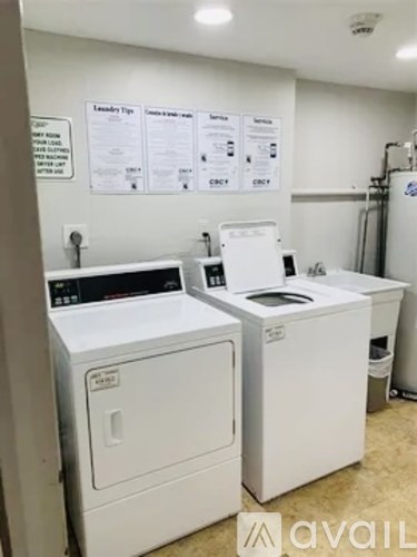 A laundry room with washers and dryers and a sign that says "Laundry Tips".