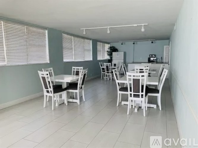 A dining room with white chairs and a table.