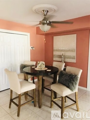 A dining room with a round table and chairs.