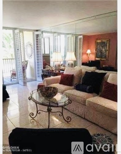 A living room with a glass table and a couch.