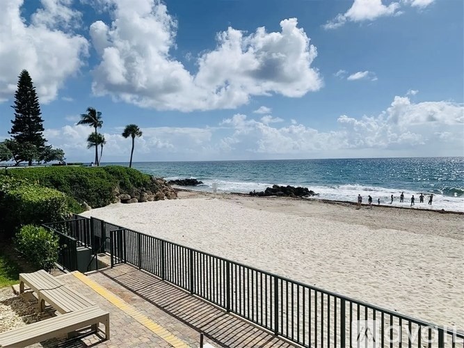 A beach scene with a wooden walkway leading to the sand.