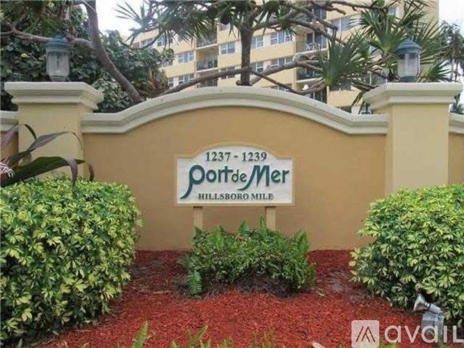A sign for a property at 1237-1239 Porto Mer Hillsboro Mile is displayed in front of a building.