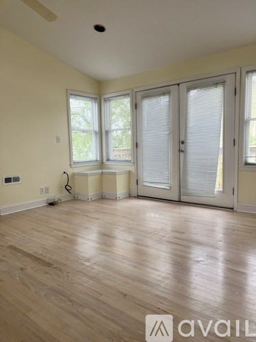 A room with wooden flooring and white walls.