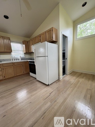 A kitchen with a white refrigerator and wooden cabinets.