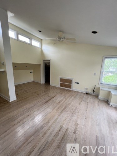 A room with wooden floors and a ceiling fan.