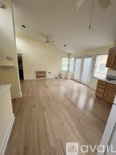 A room with wooden flooring and a ceiling fan.