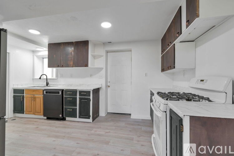 A spacious room with wooden flooring and a hanging light fixture.