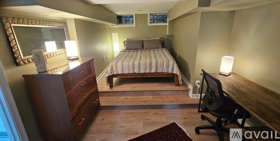 A bathroom with a toilet, tiled walls, and a walk-in shower.