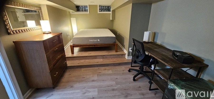 A bedroom with a bed, desk, and chair.