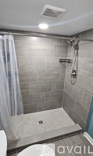 A blue door is on the left side of a brown wall with a window and a small plant.