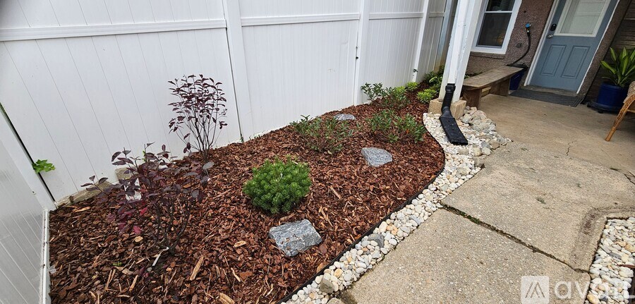 A garden with a white fence and a grey door.
