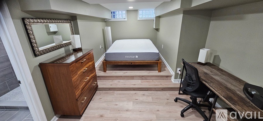 A bedroom with a bed, dresser, and desk.