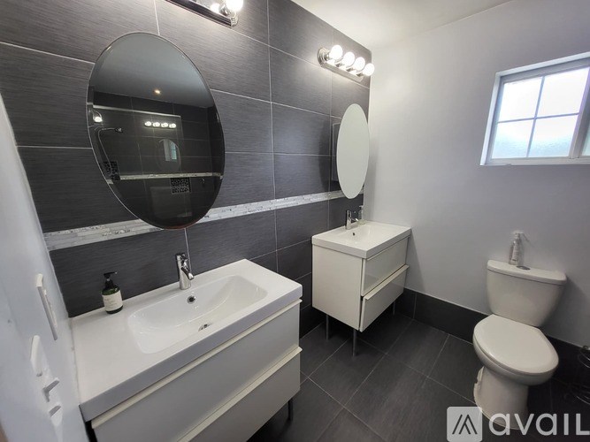 A bathroom with a sink, toilet, and mirror.