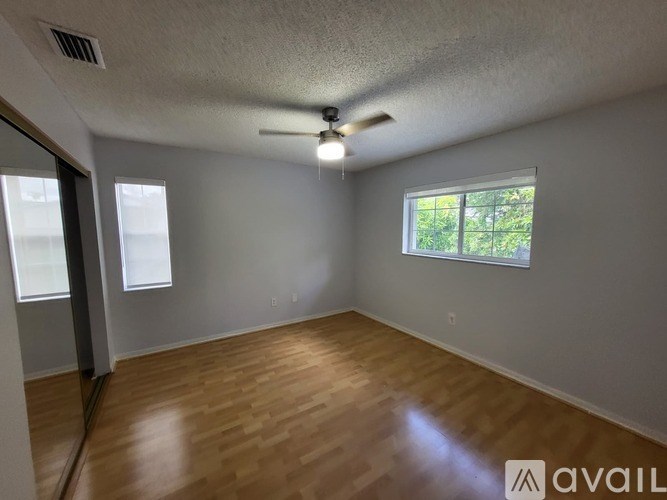 A room with wooden flooring and a ceiling fan.