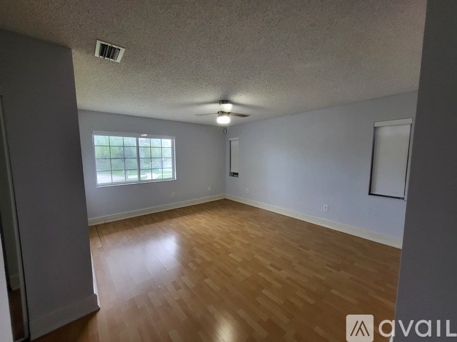 A room with wooden flooring and a window.