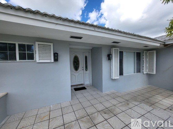 A house with a white door and windows with shutters.