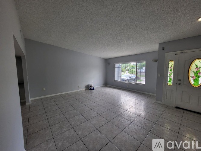 A room with a tiled floor and a door with a stained glass window.