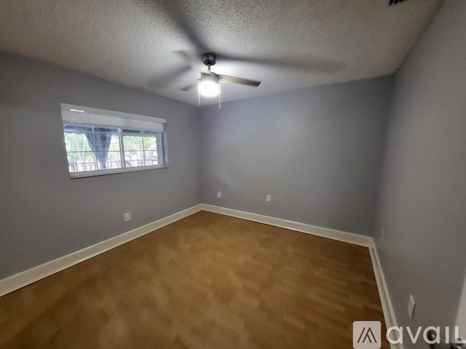 A room with a ceiling fan and a window.