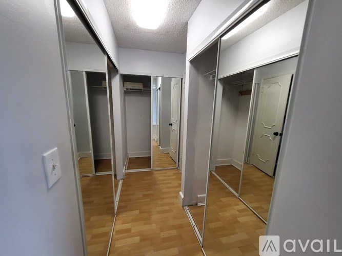 A hallway with mirrors on both sides and wooden floors.