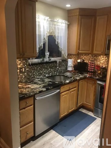 A kitchen with wooden cabinets and a black granite countertop.
