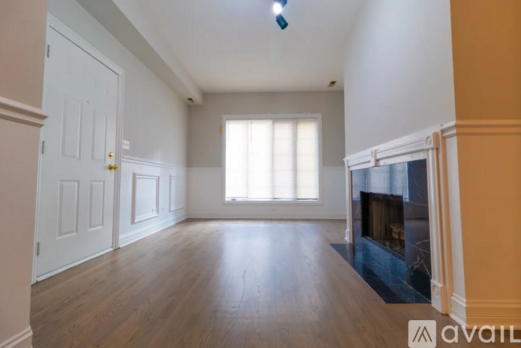 A spacious room with a fireplace and a window.