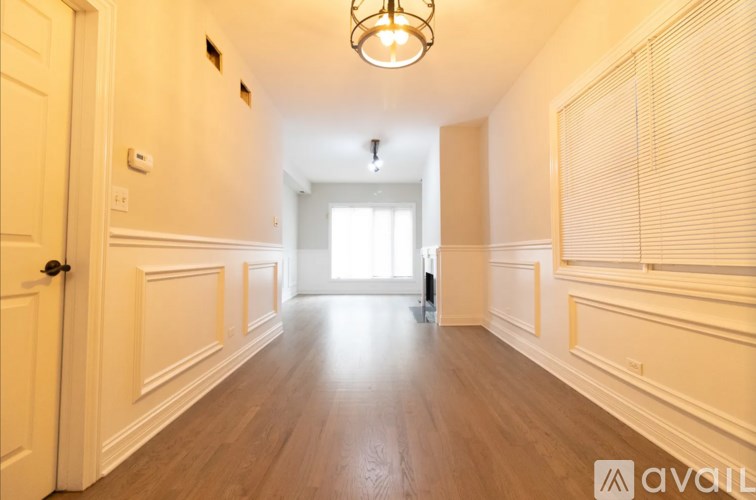 A hallway with wooden floors and white walls.
