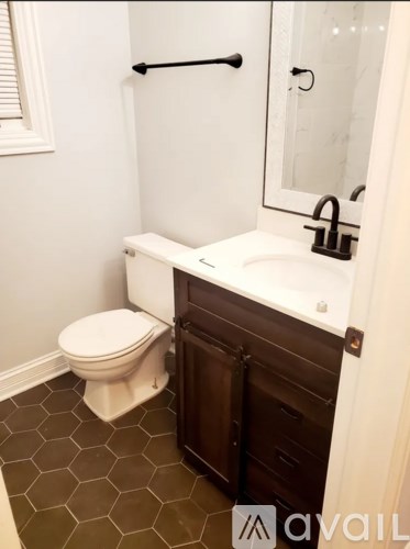 A white toilet sits next to a sink in a small bathroom.