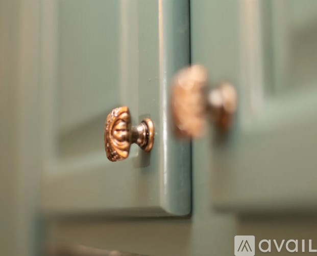 A close up of a copper door knob on a cabinet.