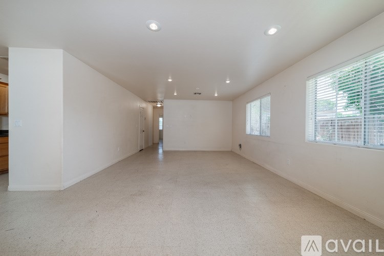 A spacious empty room with white walls and carpeted floor.