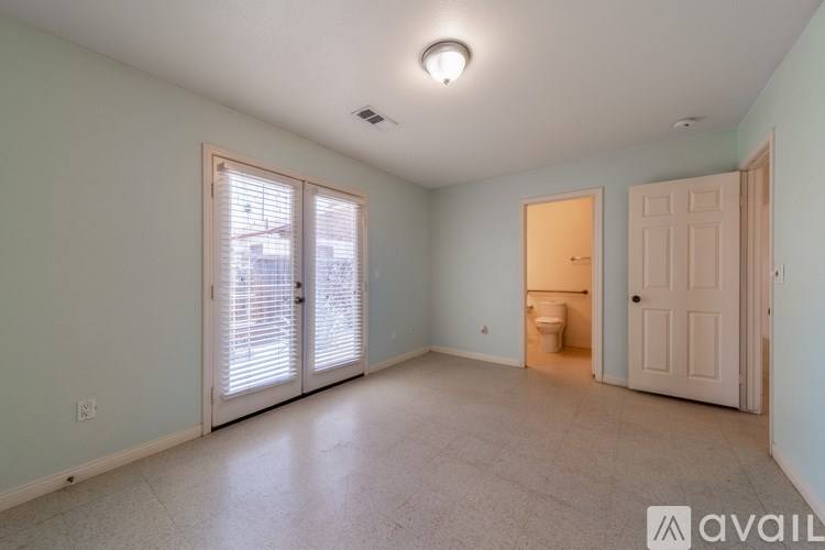 A room with a toilet in the corner and a door to the right.