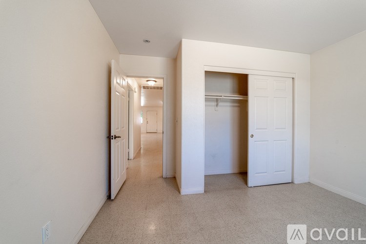 A spacious room with a hallway leading to another room.