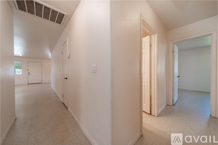 A hallway with white walls and a carpeted floor.