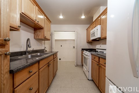 A kitchen with wooden cabinets and a black countertop.