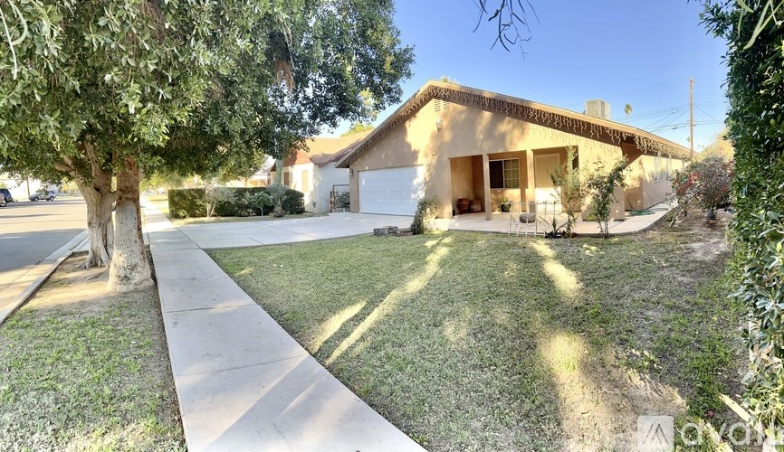 A house with a driveway and a tree in front.