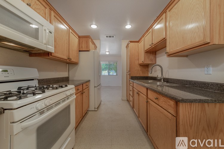 A kitchen with wooden cabinets and a white stove top oven.
